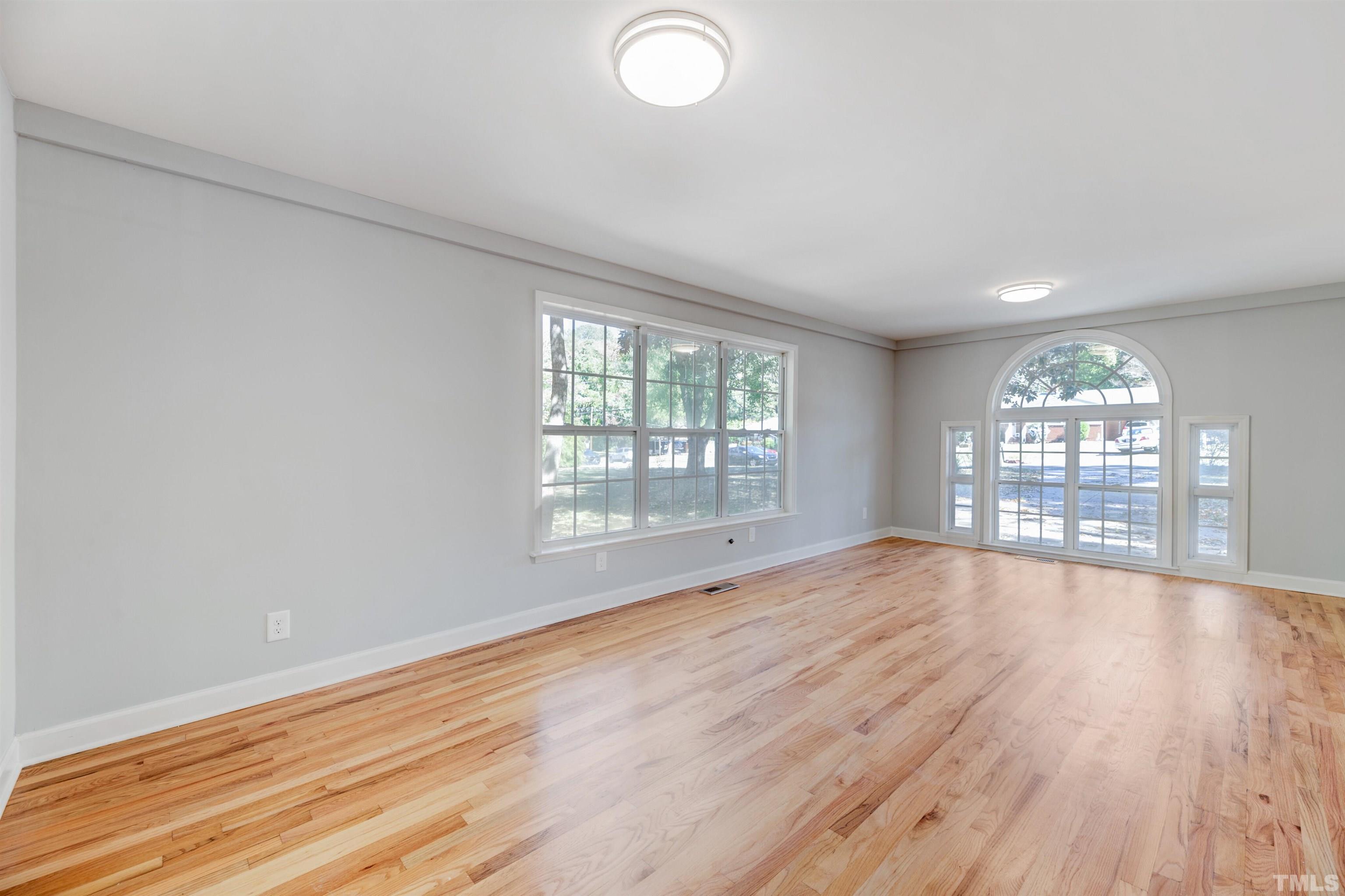 618 Starmont Drive Durham, NC 27705 - Photo 19 of 45 an empty room with wooden floor and windows