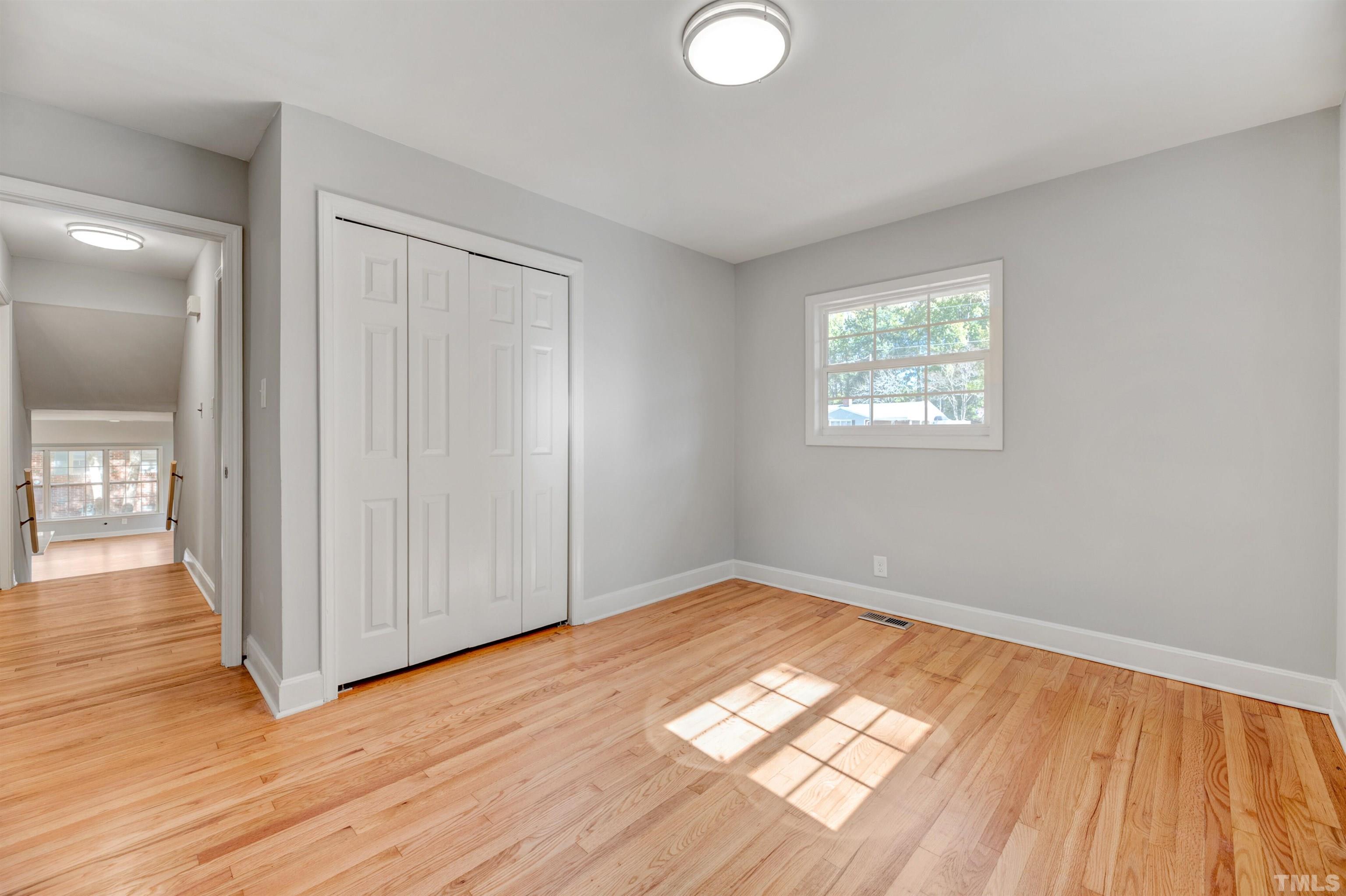 618 Starmont Drive Durham, NC 27705 - Photo 25 of 45 an empty room with wooden floor and windows