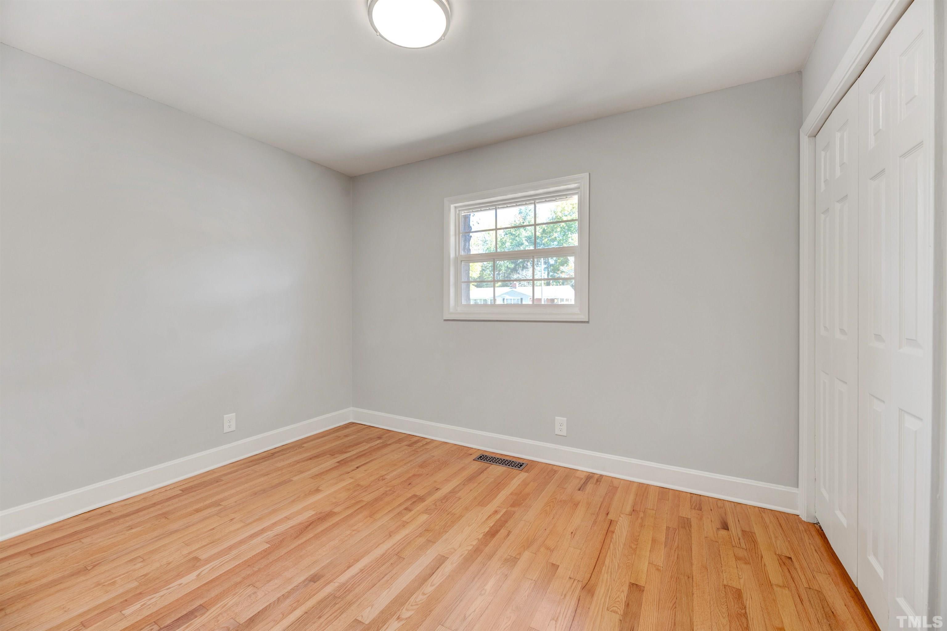 618 Starmont Drive Durham, NC 27705 - Photo 26 of 45 an empty room with wooden floor and windows