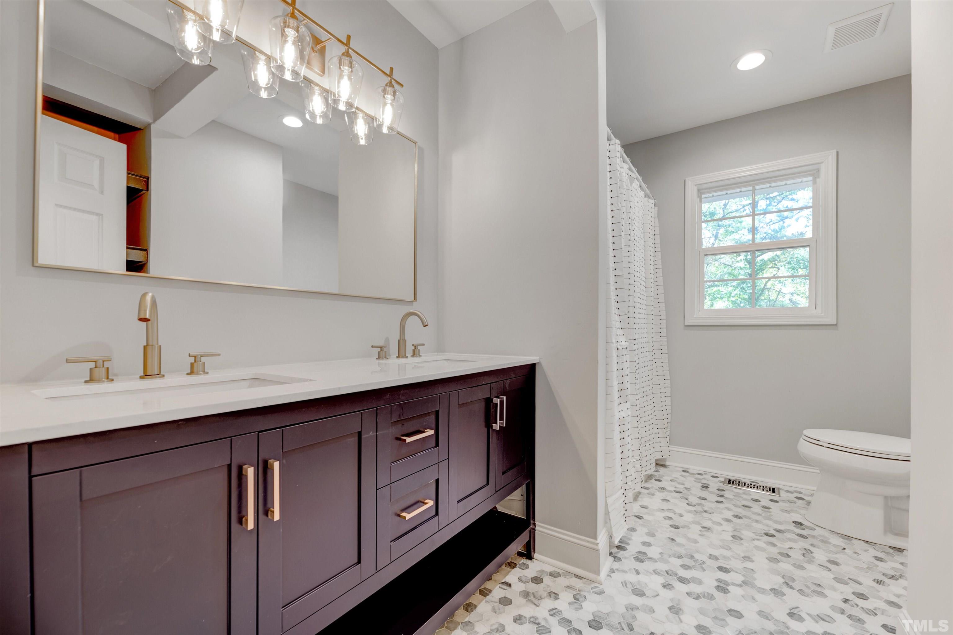 618 Starmont Drive Durham, NC 27705 - Photo 28 of 45 a bathroom with a sink a toilet and a mirror