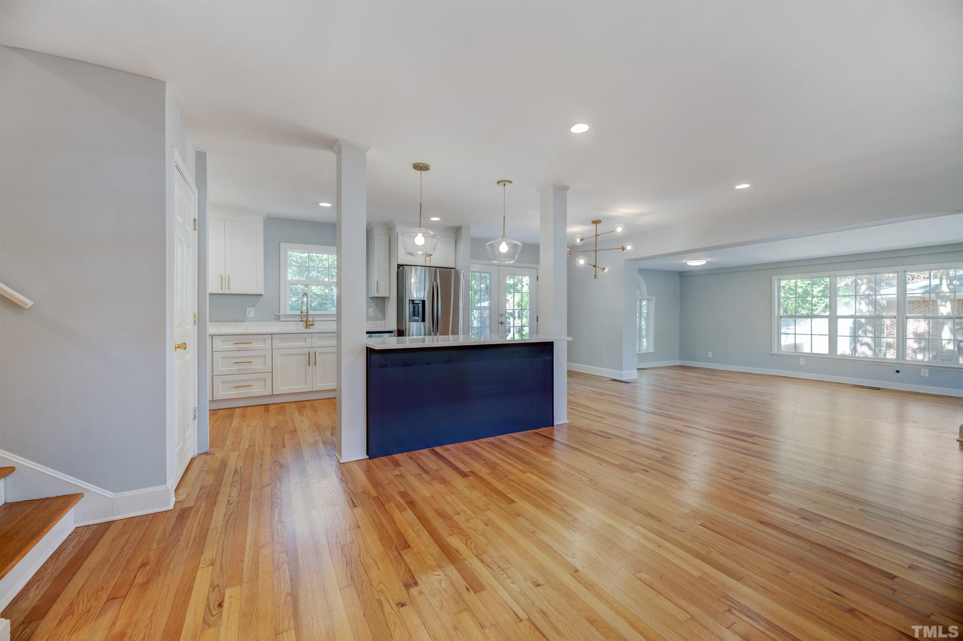 618 Starmont Drive Durham, NC 27705 - Photo 6 of 45 a open kitchen with kitchen island a sink appliances wooden floor and a living room