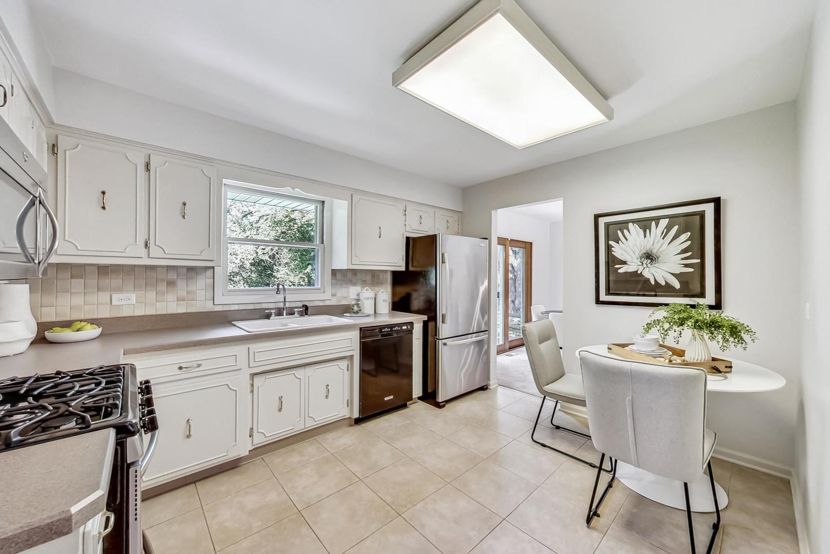 1010 S Road Lisle, IL 60532 - Photo 8 of 29 a kitchen with white cabinets and stainless steel appliances