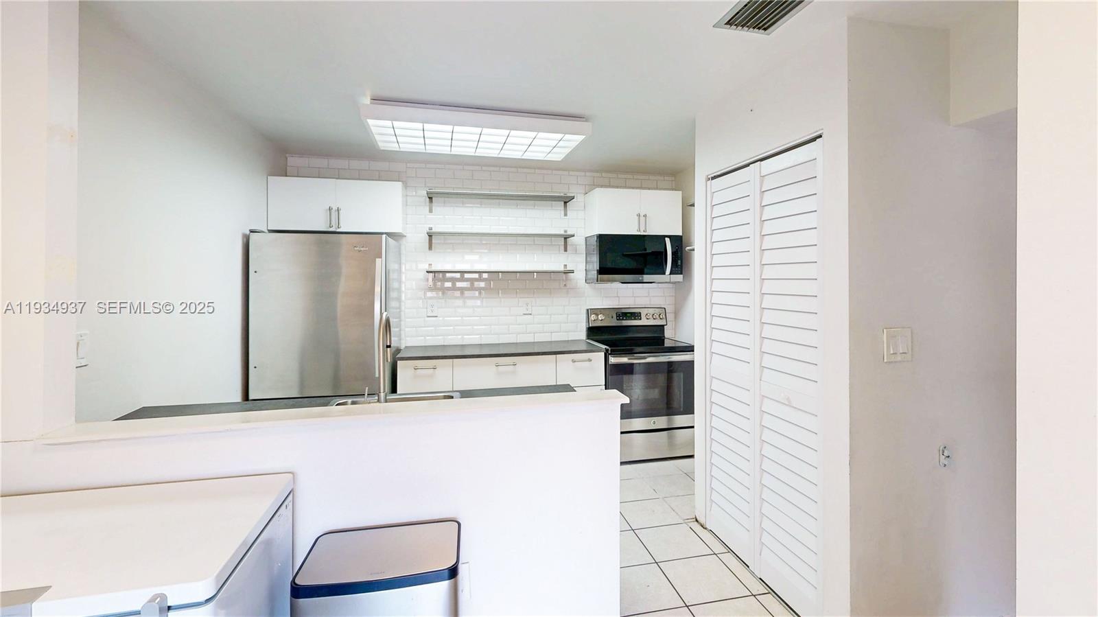 13292 Southwest 114th Terrace Miami, FL 33186 - Photo 14 of 65 a kitchen with a refrigerator and a stove top oven