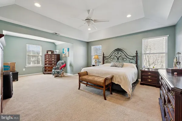a spacious bedroom with a bed and a large mirror
