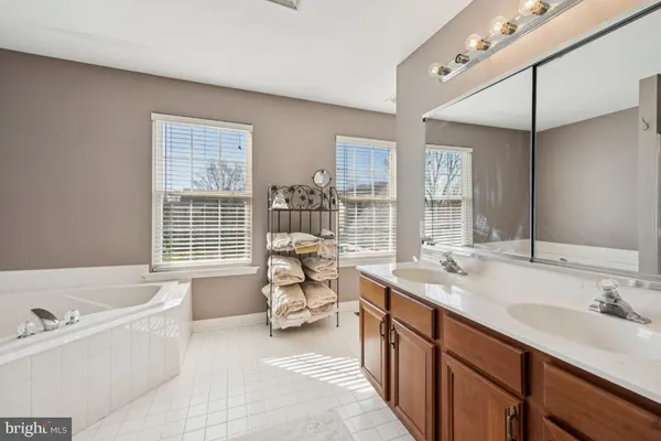 a spacious bathroom with sinks mirror and a bathtub