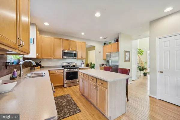 a kitchen with a refrigerator a sink dishwasher stove and oven with wooden floor