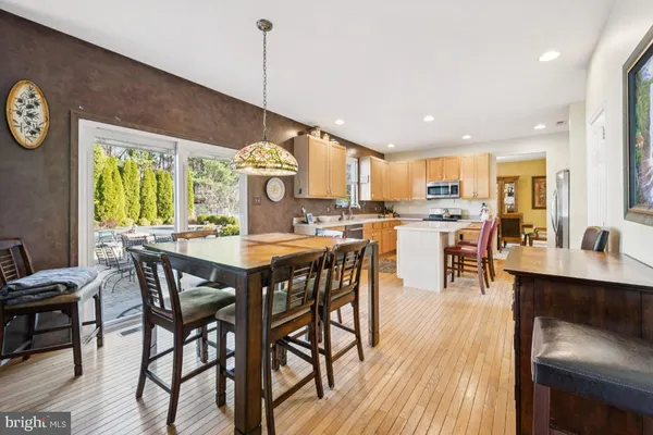 a dining room with stainless steel appliances granite countertop a stove a kitchen island a table and chairs