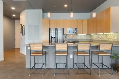 a kitchen with granite countertop a refrigerator stove top oven a sink and dishwasher