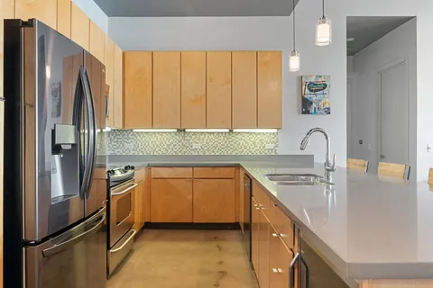 a kitchen with stainless steel appliances kitchen island granite countertop a table and chairs