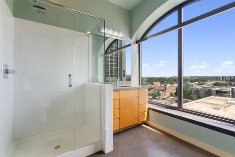 a bathroom with a granite countertop sink a mirror and shower