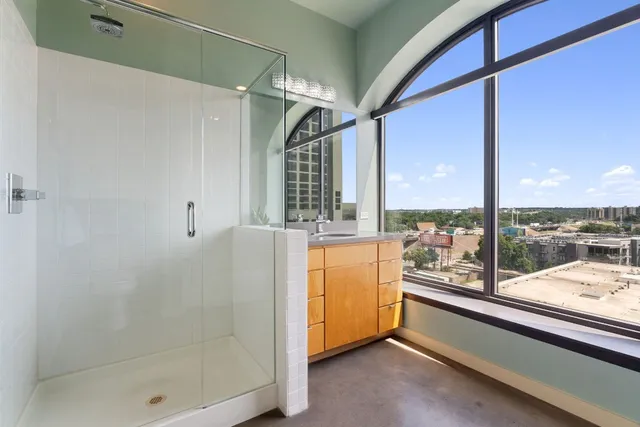 a bathroom with a granite countertop sink a mirror and shower