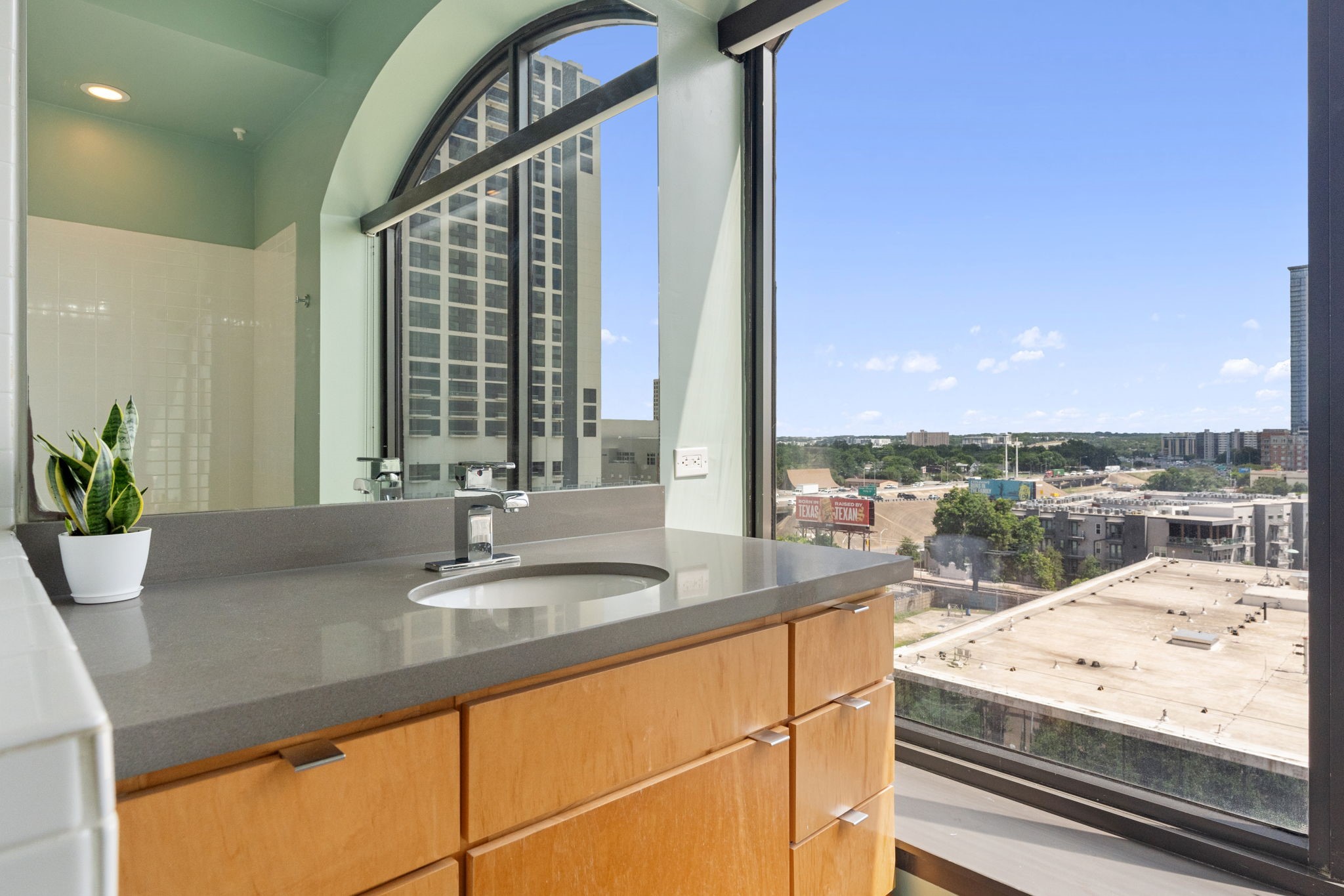 507 Sabine Street, Unit 605 Austin, TX 78701 - Photo 24 of 33 a bathroom with a granite countertop sink and a large mirror