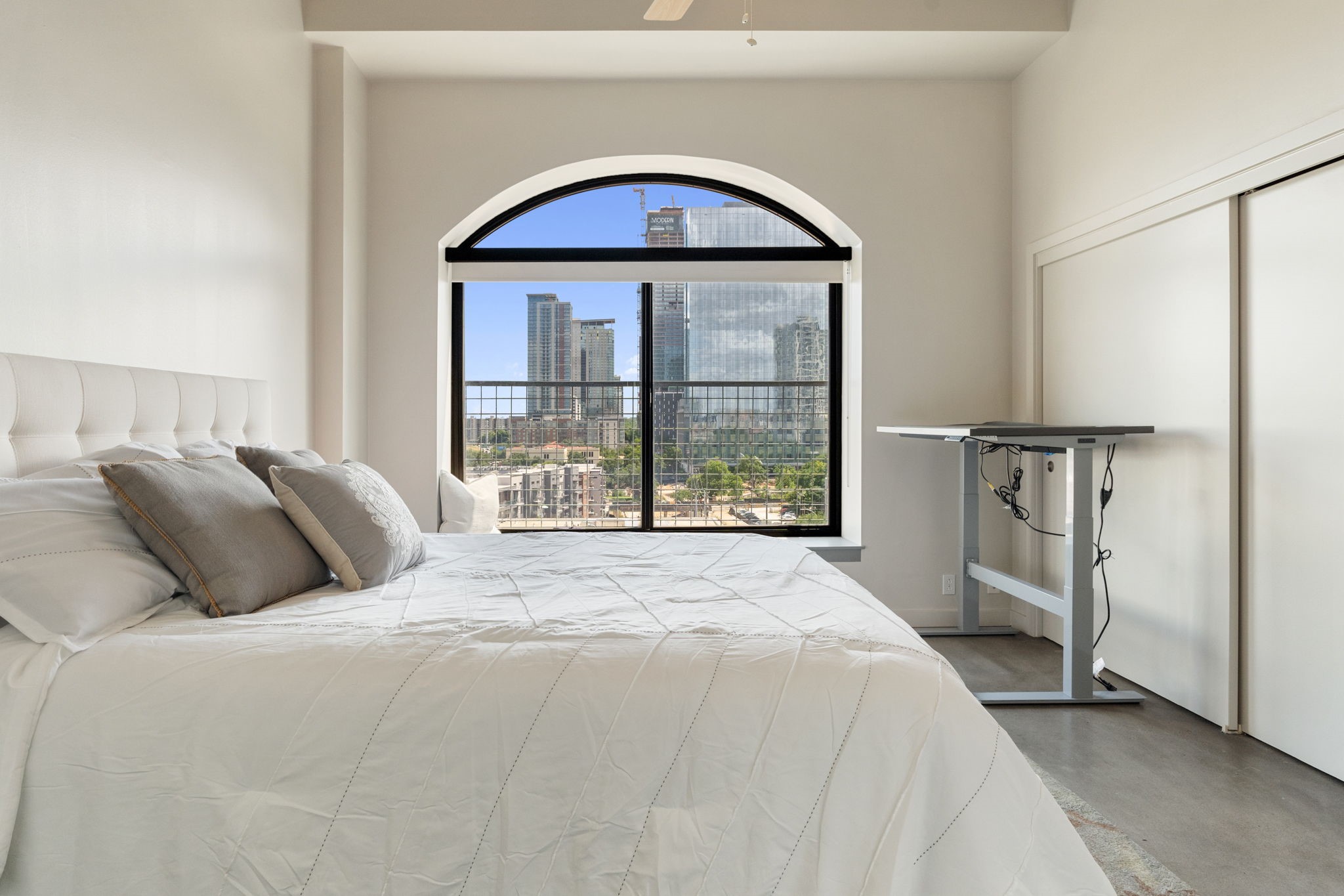 507 Sabine Street, Unit 605 Austin, TX 78701 - Photo 26 of 33 a bedroom with a balcony a bed and a window