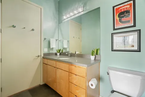 a bathroom with a granite countertop sink a toilet a mirror and bathtub