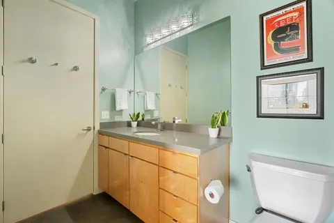 a bathroom with a sink mirror vanity and toilet