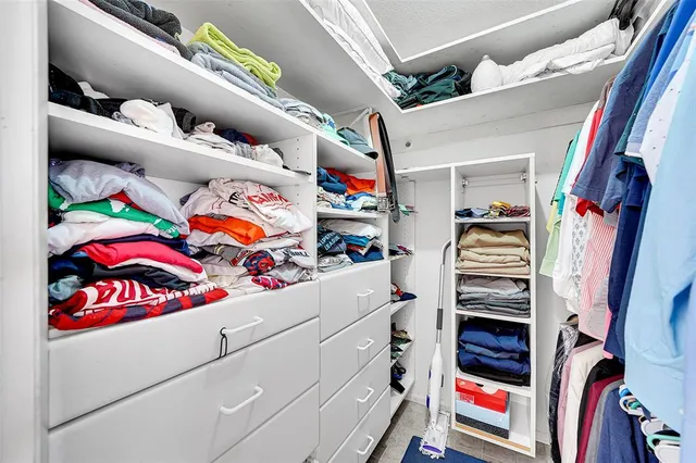 a view of walk in closet with clothes and shoes