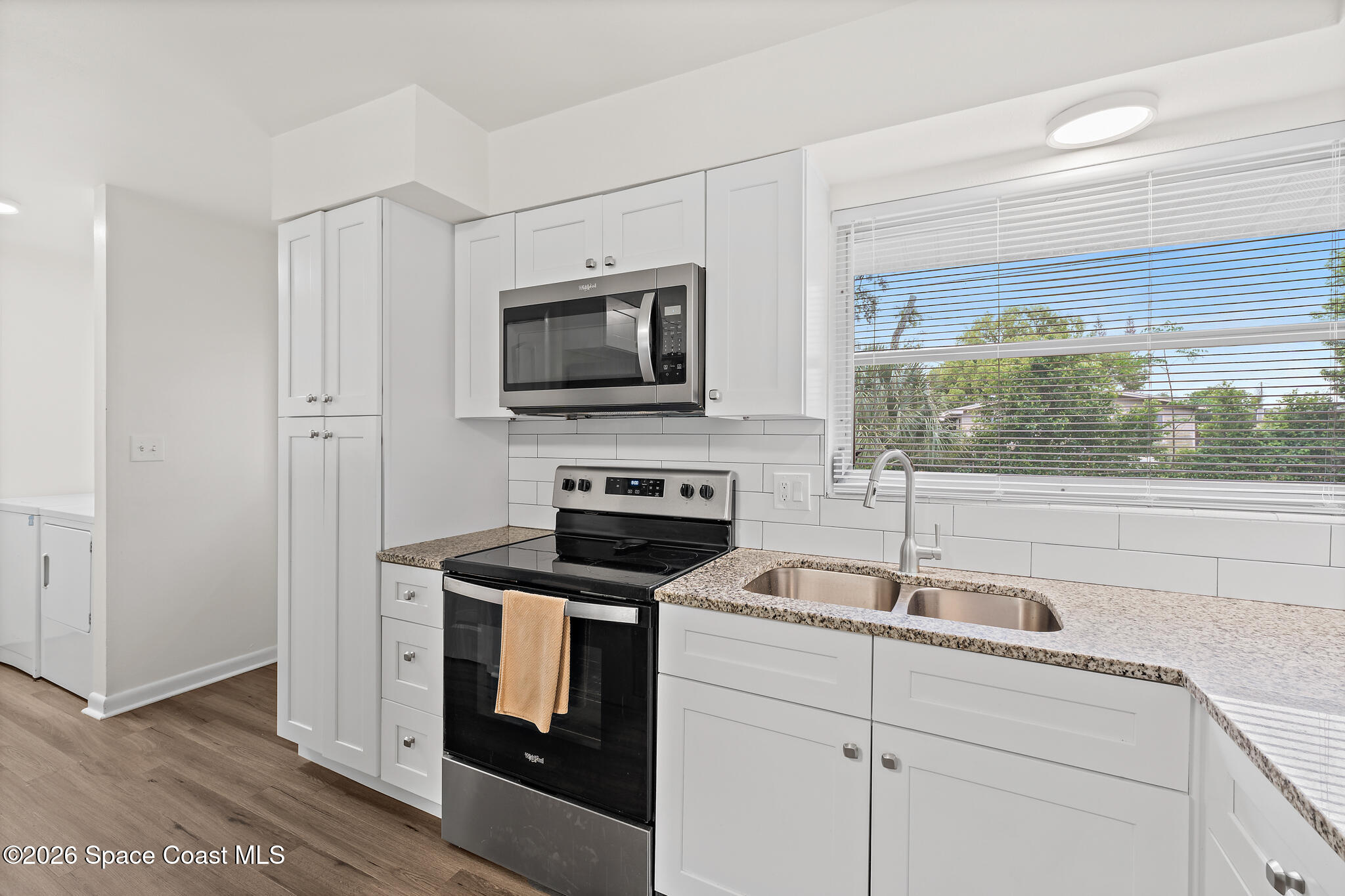 815 Glade Road Titusville, FL 32780 - Photo 4 of 30 a kitchen with a sink stove and microwave
