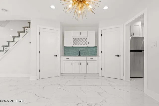 a kitchen with white cabinets and appliances
