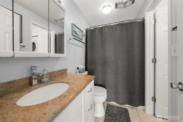 a en suite bathroom with a granite countertop toilet and a sink