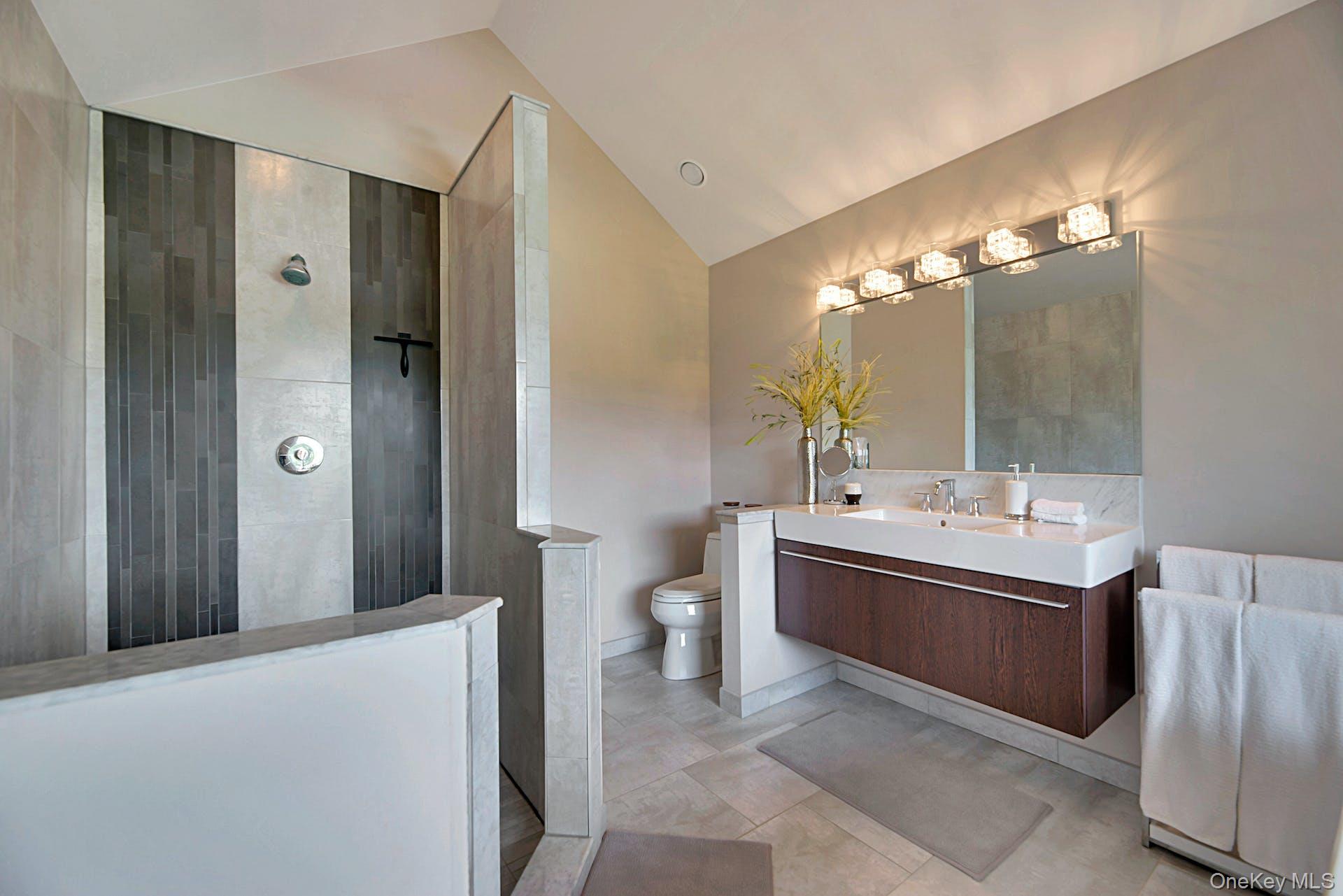 450 Sterling Woods Lane Southold, NY 11971 - Photo 17 of 41 a bathroom with a bathtub sink vanity and toilet