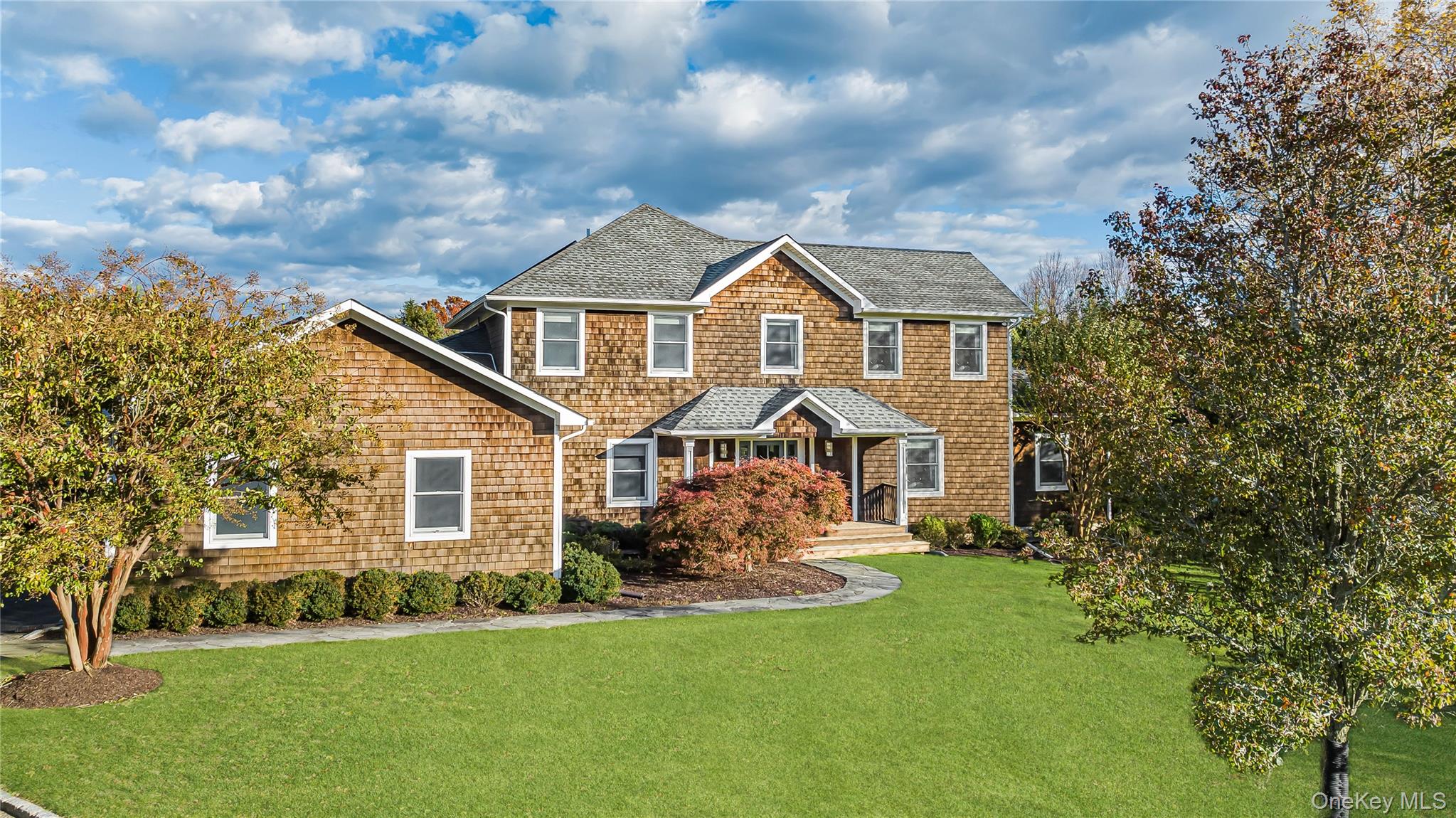 450 Sterling Woods Lane Southold, NY 11971 - Photo 2 of 41 a front view of a house with a garden and trees