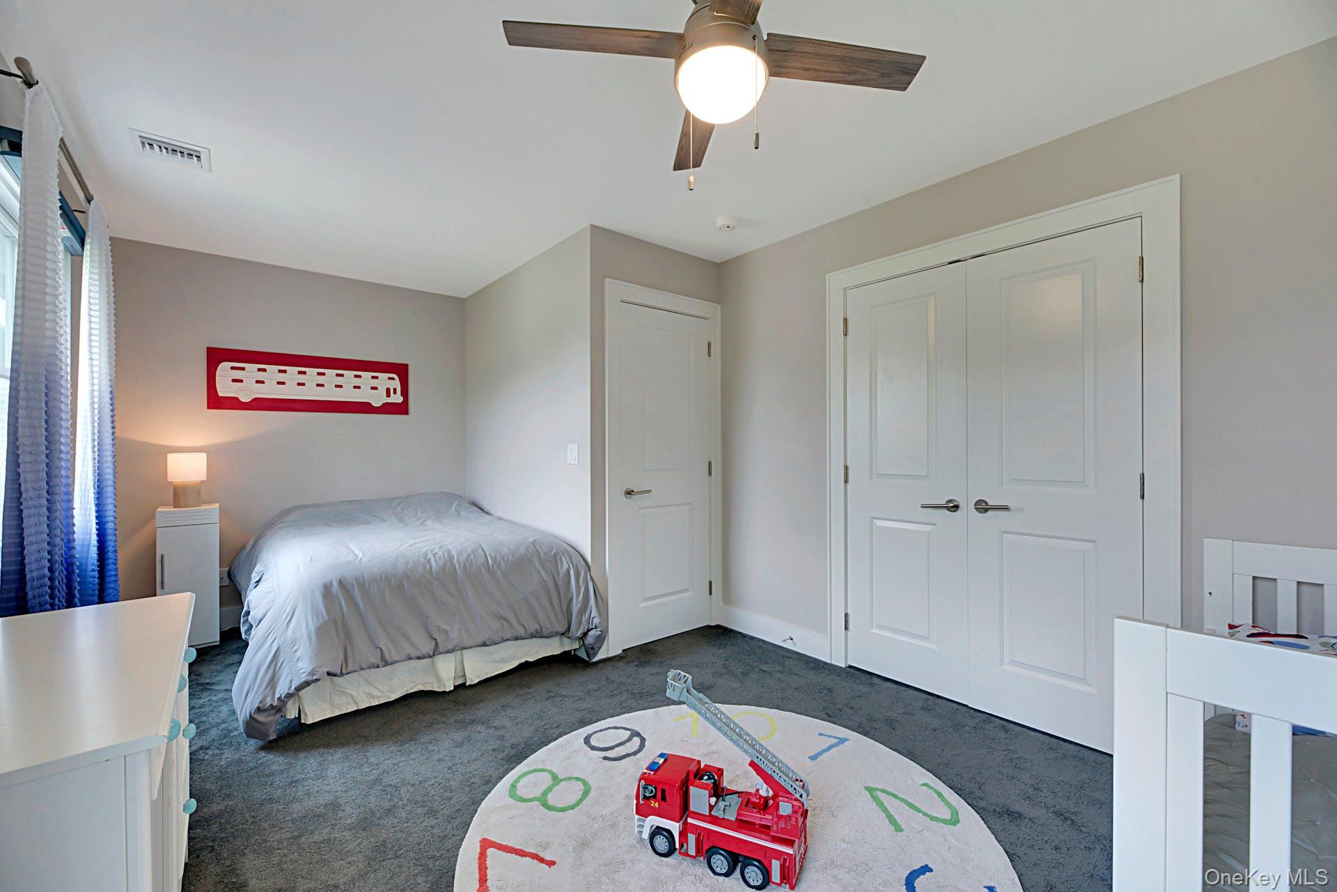 450 Sterling Woods Lane Southold, NY 11971 - Photo 22 of 41 a bedroom with a bed and a chandelier