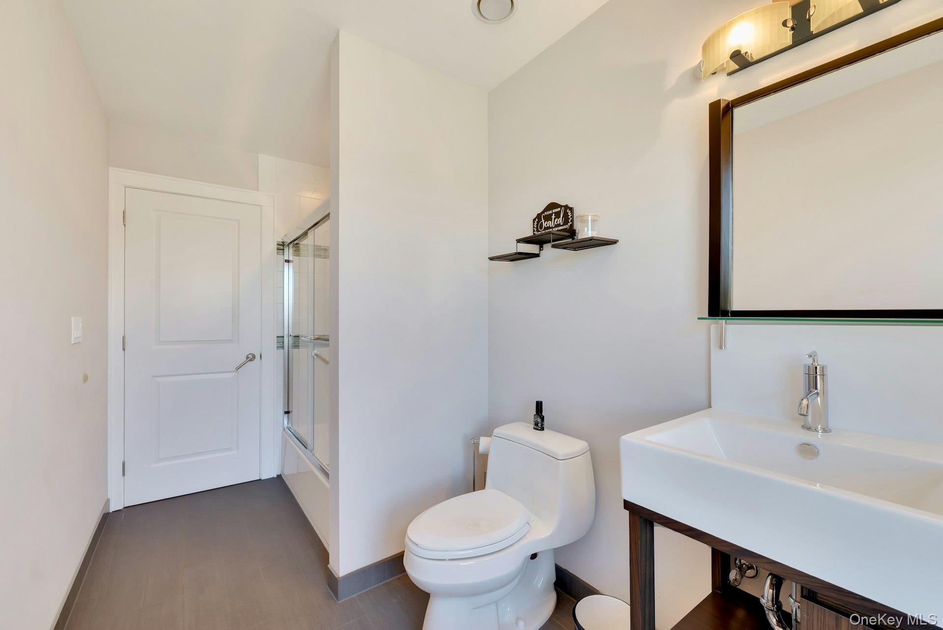 450 Sterling Woods Lane Southold, NY 11971 - Photo 25 of 41 a bathroom with a sink toilet and a mirror