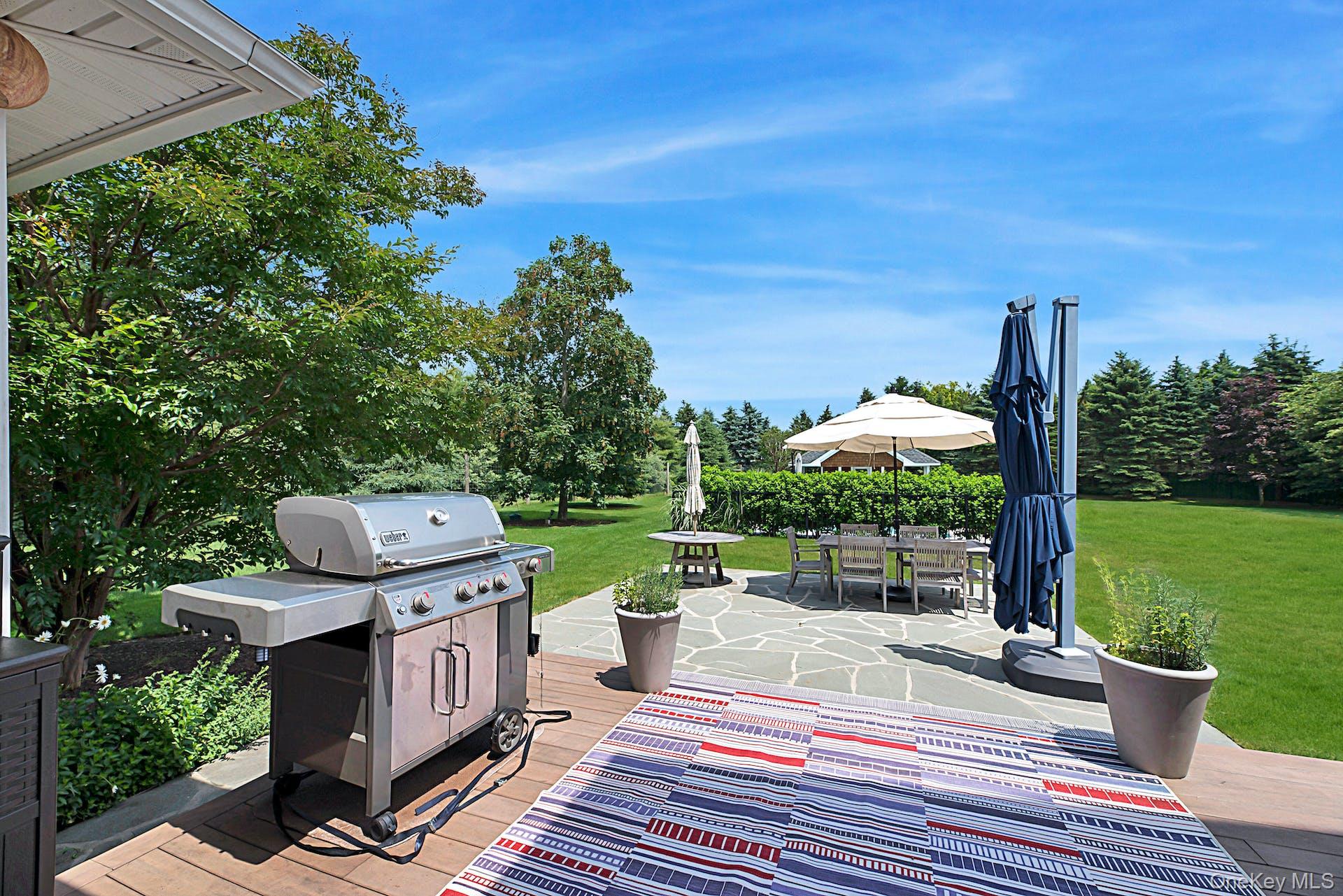 450 Sterling Woods Lane Southold, NY 11971 - Photo 28 of 41 a view of a patio with table and chairs potted plants with wooden fence