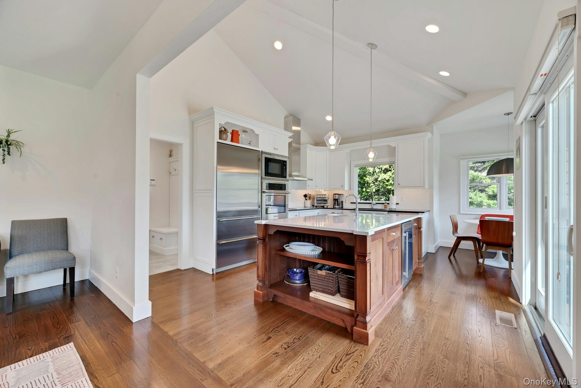 450 Sterling Woods Lane Southold, NY 11971 - Photo 10 of 41 a kitchen with stainless steel appliances granite countertop a refrigerator a stove a sink dishwasher and a dining table with wooden floor