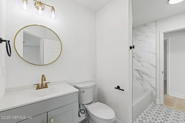 a bathroom with a sink a toilet and a mirror