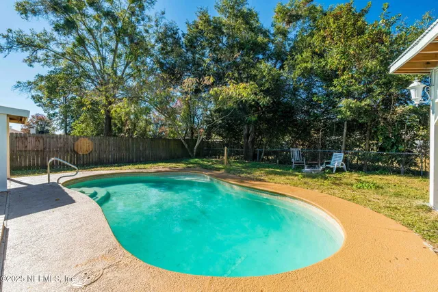 a view of a house with backyard swimming pool and sitting area