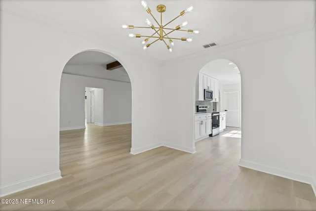 a view of a room with wooden floor and a ceiling fan