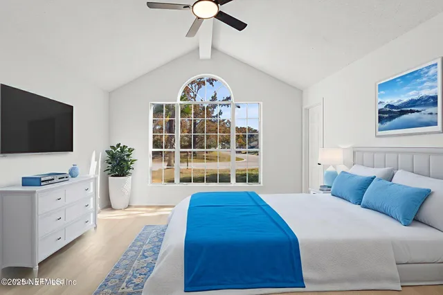 a spacious bedroom with a bed and a flat screen tv