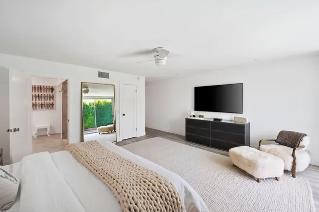 a bedroom with a bed and a flat screen tv