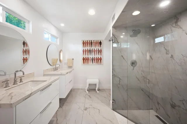 a spacious bathroom with a granite countertop sink a mirror and a shower