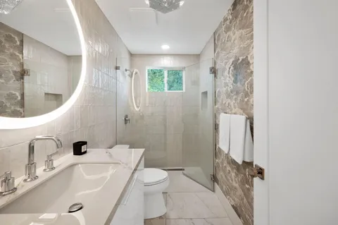 a bathroom with a sink a toilet and shower