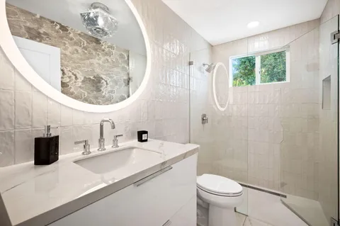 a bathroom with a sink a toilet and a mirror