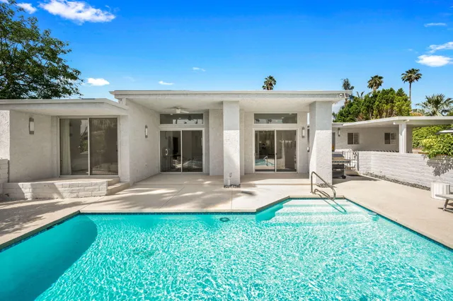 a view of a house with backyard porch and sitting area