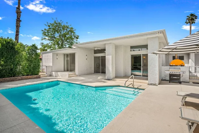 a view of a house with swimming pool and sitting area
