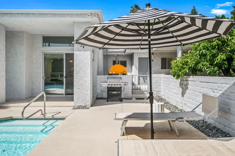 a roof deck with table and chairs under an umbrella