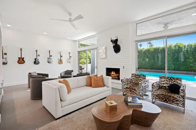 a living room with furniture a large window and a fireplace