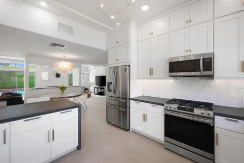a kitchen with stainless steel appliances granite countertop a stove a refrigerator and a microwave