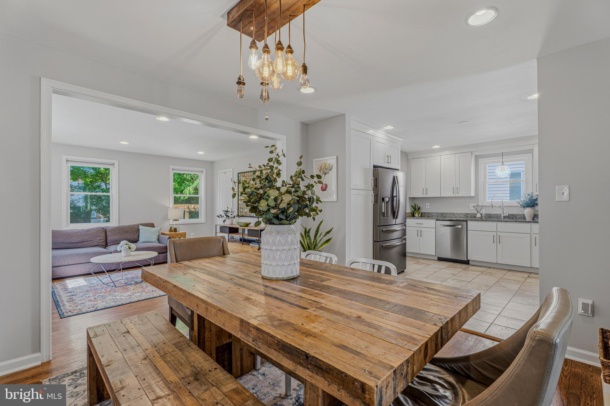 506 Brook Road Baltimore, MD 21286 - Photo 12 of 56 a dining room with wooden floor a chandelier a wooden table and chairs