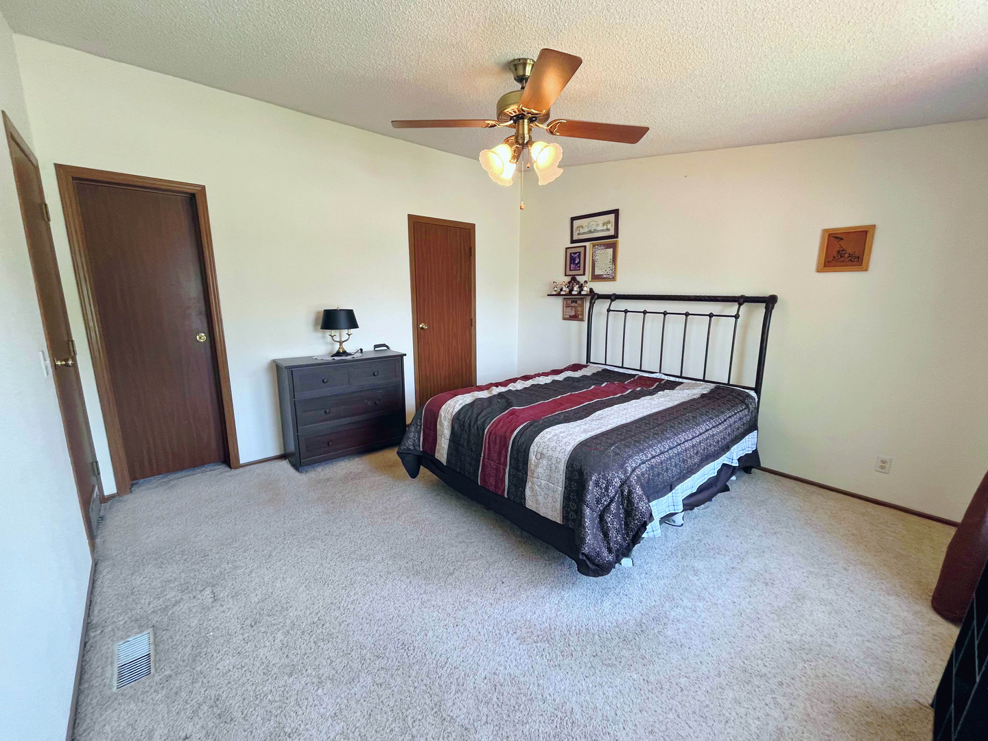 113 Cardinal Lane Sandwich, IL 60548 - Photo 12 of 14 a spacious bedroom with a bed and a chandelier
