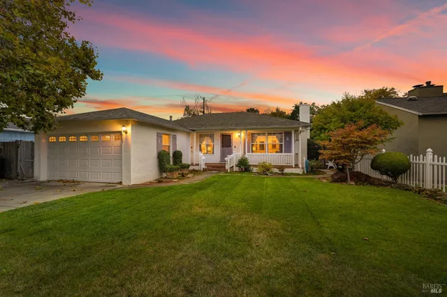 a front view of a house with a yard and trees