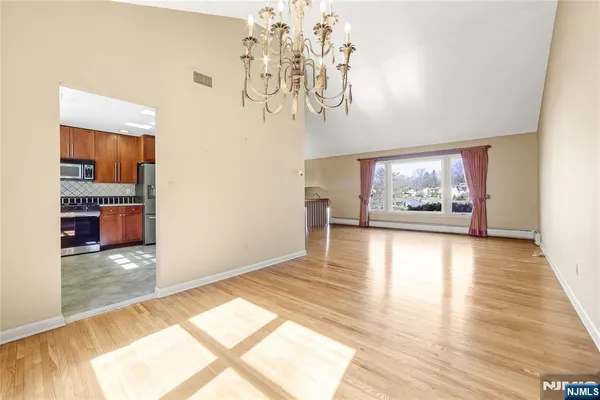 a kitchen with stainless steel appliances granite countertop a refrigerator a sink a stove and white cabinets