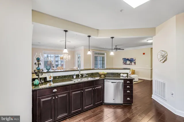 a kitchen with stainless steel appliances granite countertop a sink a stove and a wooden floors