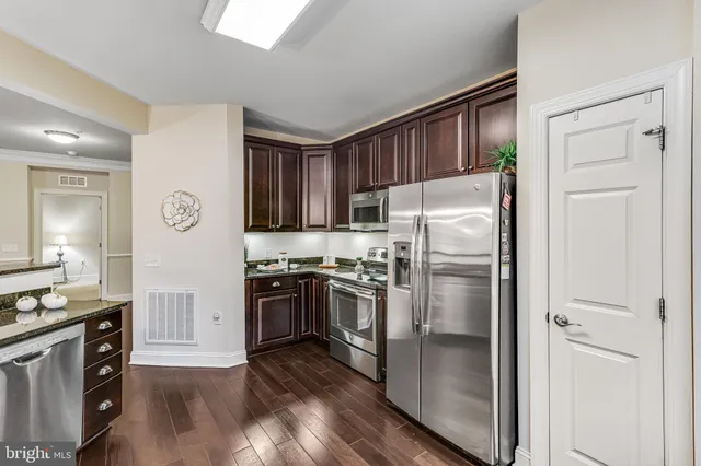 a kitchen with stainless steel appliances granite countertop a stove a sink and a refrigerator