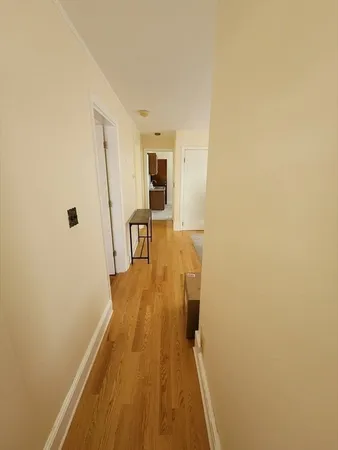a view of a hallway with wooden floor and furniture