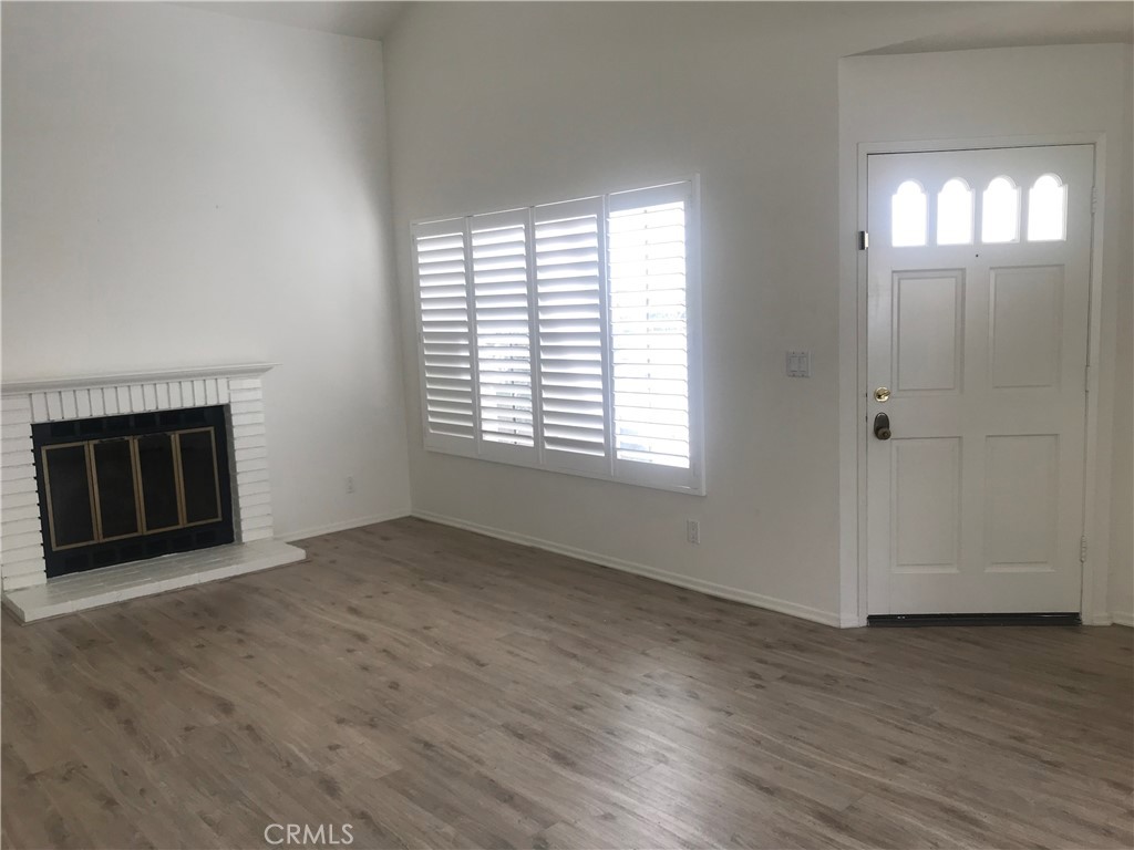 21 Silkberry Irvine, CA 92614 - Photo 4 of 18 an empty room with wooden floor a fireplace and windows